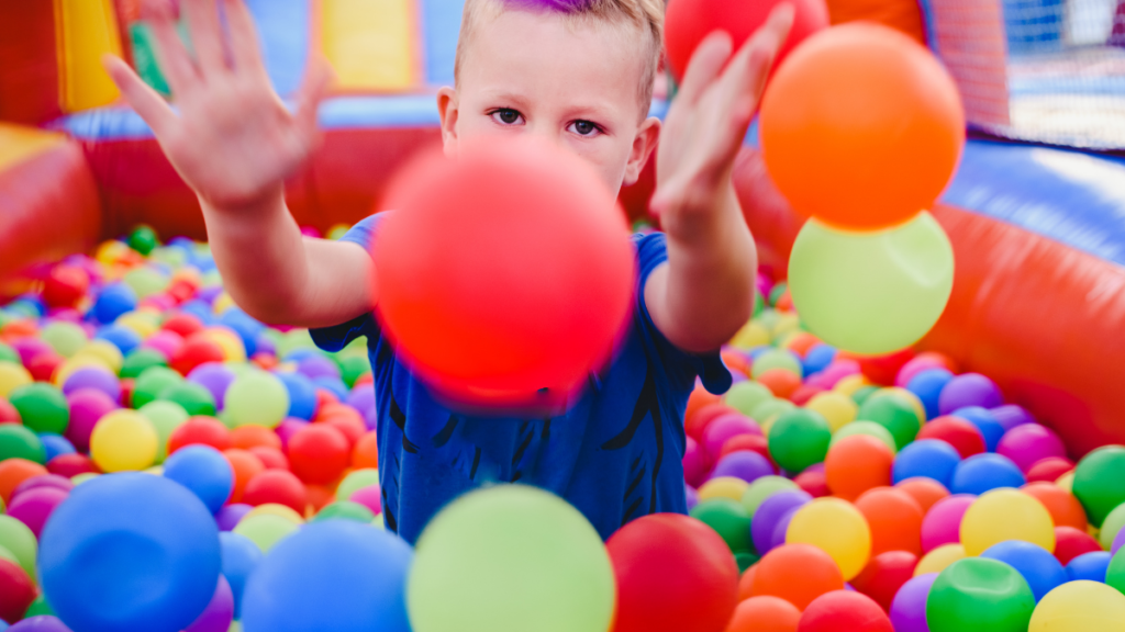 Imagen de un niño jugando en una piscina de bolas