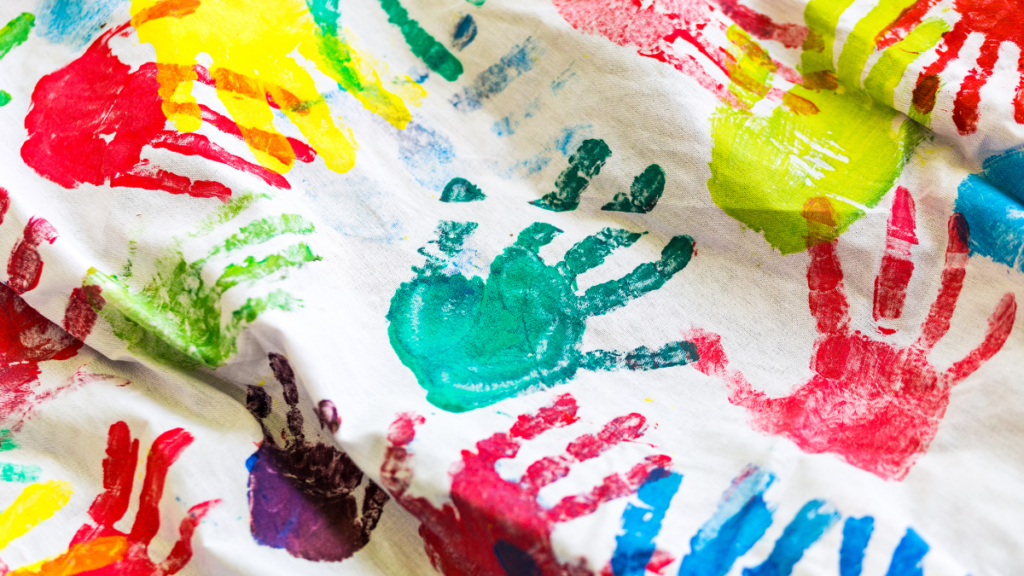 Imagen de una tela con huellas de manos de colores