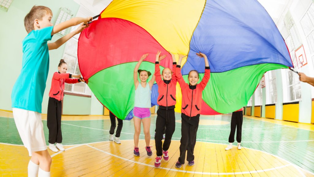 Un grupo de niños y niñas jugando con un paracaidas de colores